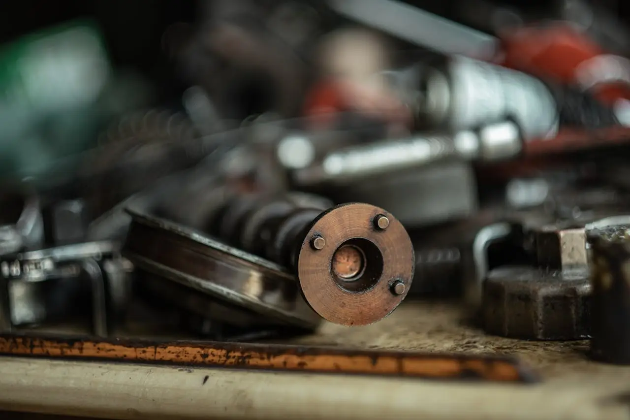 Detailed view of metal components in an automotive workshop. Focus on a cylindrical piece.